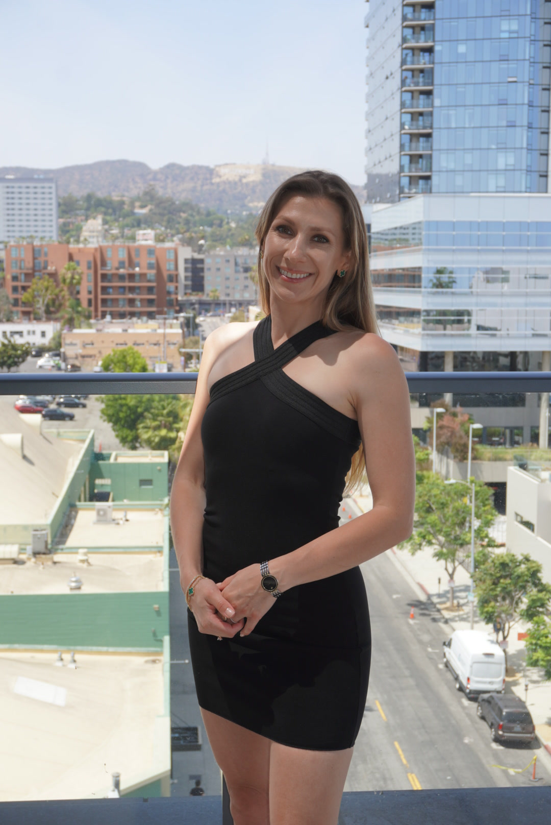 Viktoryia on a Los Angeles balcony with the city behind her.